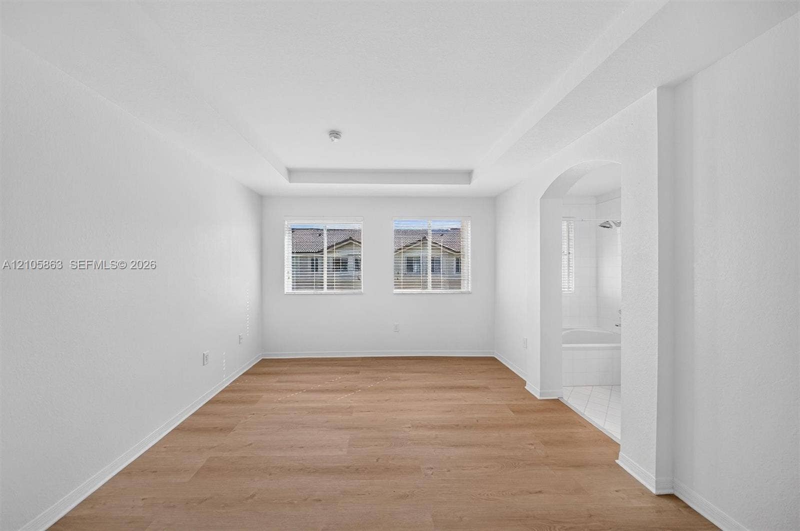 8846 W Flagler Street, #5, Miami, FL 33174 Interior space featuring wood-finish flooring, a recessed tray ceiling, and dual windows