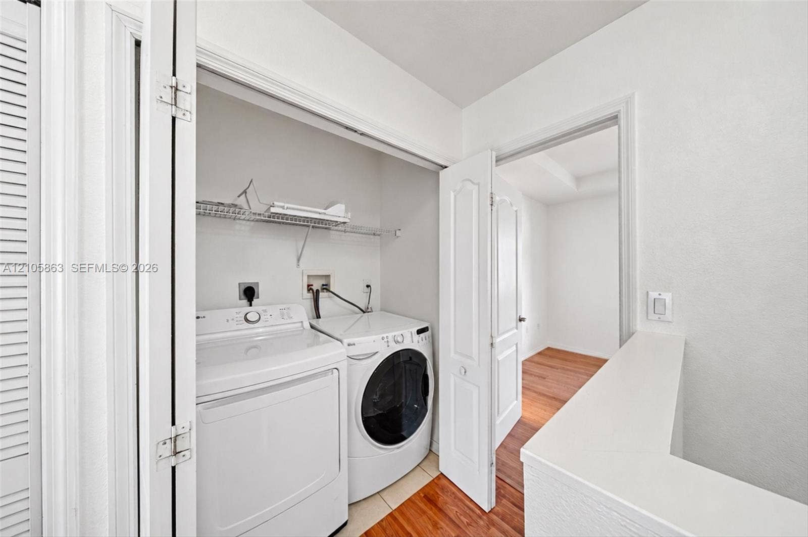 8846 W Flagler Street, #5, Miami, FL 33174 Dedicated laundry closet featuring wire shelving, side-by-side appliance hookups, and bi-fold door entry