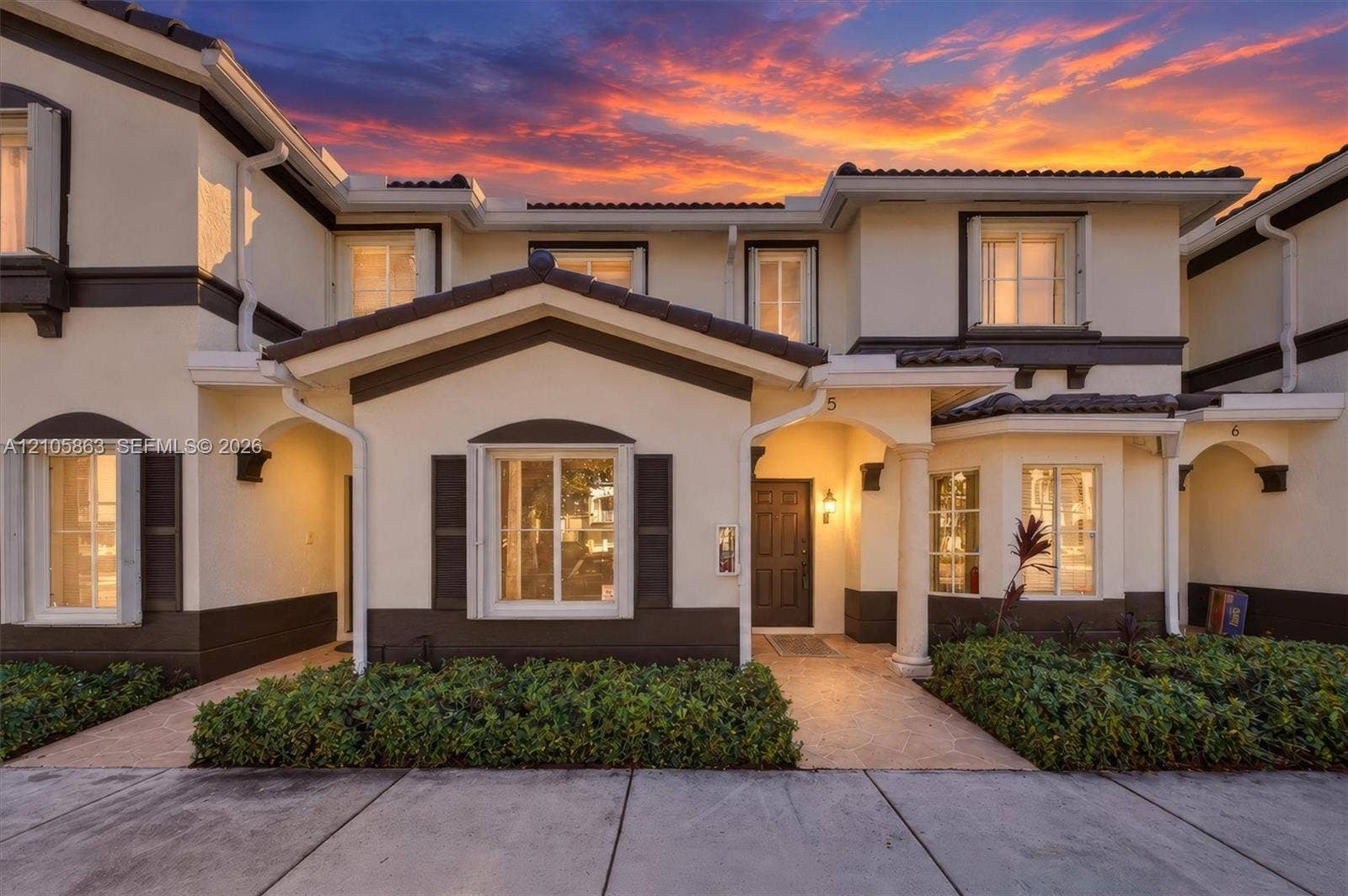 8846 W Flagler Street, #5, Miami, FL 33174 Two-story residence exterior featuring a high-contrast stucco facade, dark-toned trim, a covered entryway with a decorative column, and muntin-style windows