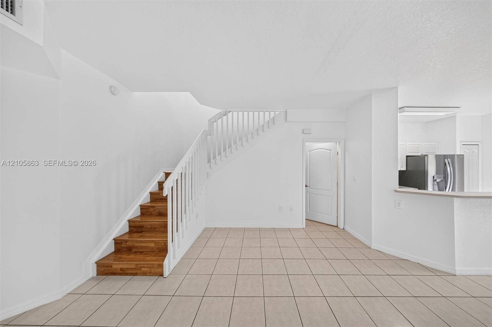 8846 W Flagler Street, #5, Miami, FL 33174 Interior featuring tiled flooring, a staircase with wood-finish treads, and a white balustrade