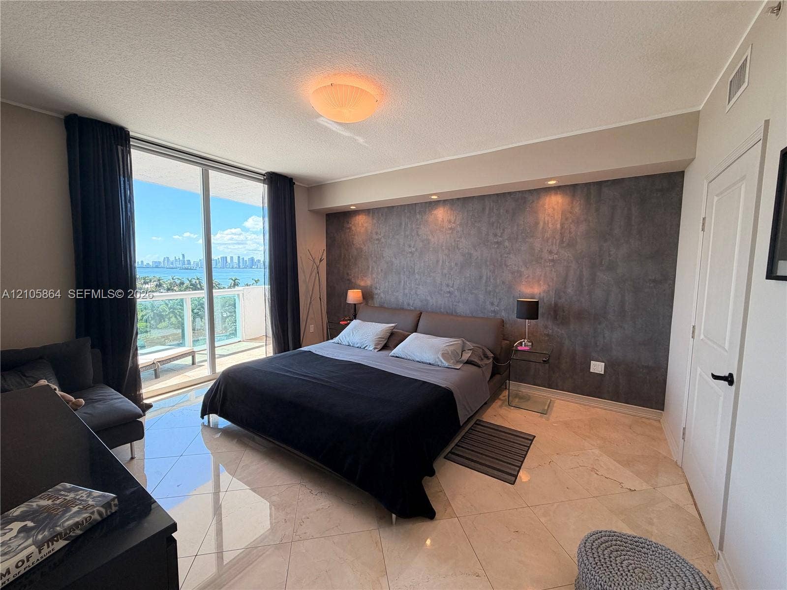 Floor-to-ceiling sliding glass doors, decorative stone-finish accent wall, built-in recessed ceiling lighting, and polished stone-finish tile flooring