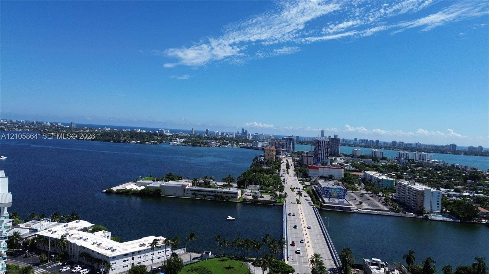 Aerial perspective featuring expansive waterway frontage, multi-level coastal development, bridge infrastructure, and maritime access points