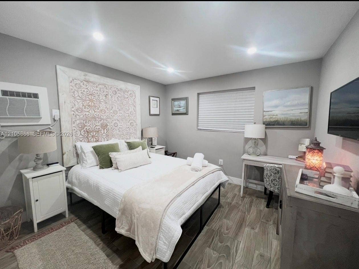 11241 SW 7th Terrace, Sweetwater, FL 33174 Main house bedroom 1 Neutral-toned walls, wood-finish flooring, recessed lighting, and a decorative wall-mounted accent panel