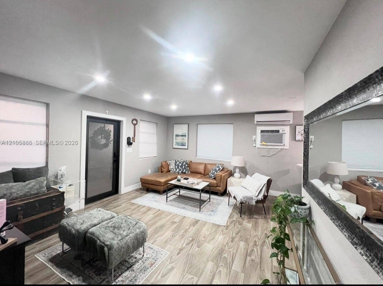11241 SW 7th Terrace, Sweetwater, FL 33174 Interior space featuring wood-finish flooring, recessed lighting, wall-mounted air conditioning unit, and a glass-paneled exterior door