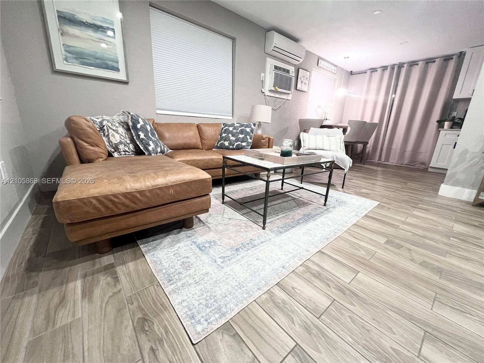 11241 SW 7th Terrace, Sweetwater, FL 33174 Living area featuring wood-finish tile flooring, recessed lighting, and wall-mounted climate control unit