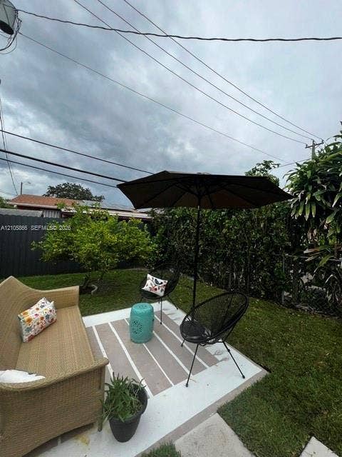 11241 SW 7th Terrace, Sweetwater, FL 33174 1/1's Backyard featuring a concrete patio, perimeter privacy fencing, and established shrubbery