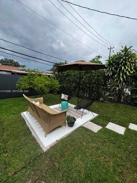 11241 SW 7th Terrace, Sweetwater, FL 33174 1/1's Backyard featuring a concrete patio, perimeter privacy fencing, and established shrubbery