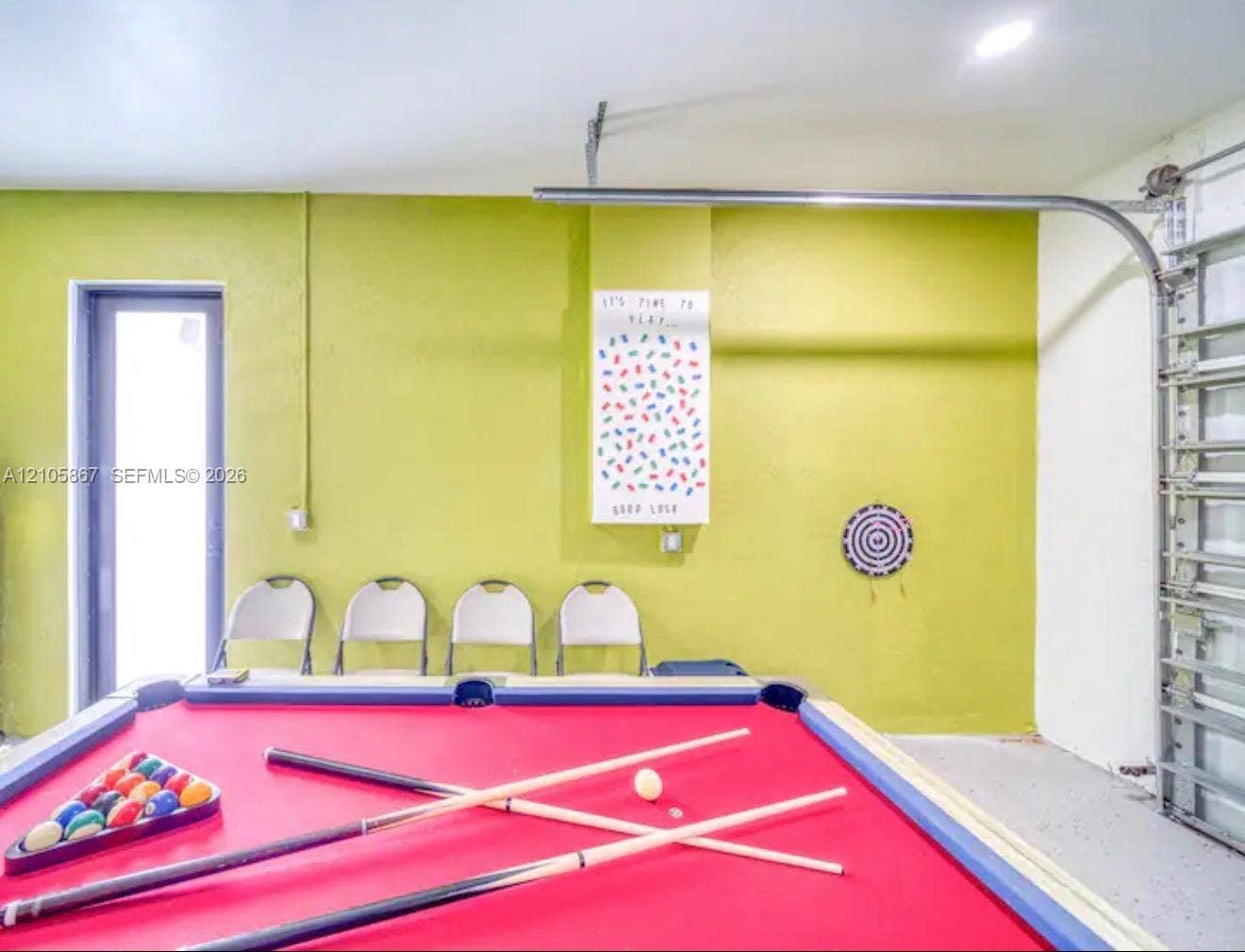 Garage space featuring recessed ceiling lighting, a single-lite glass entry door, and an overhead sectional door mechanism