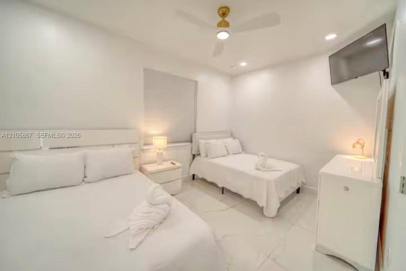 Large-format tile flooring, recessed lighting, and an overhead ceiling fan
