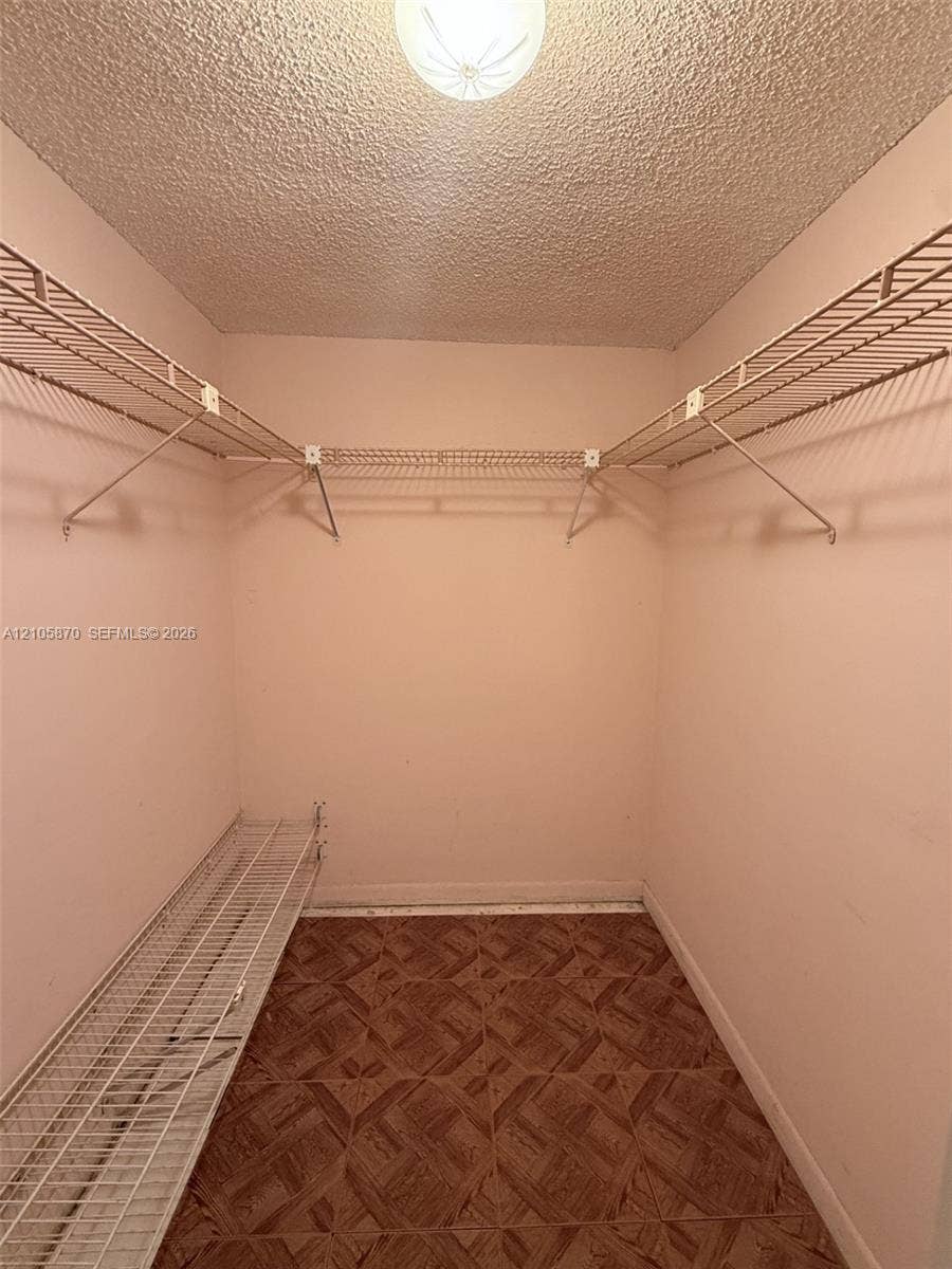 7173 Orange Drive, #204B, Davie, FL 33314 Walk-in closet featuring tiered wire shelving and patterned vinyl flooring