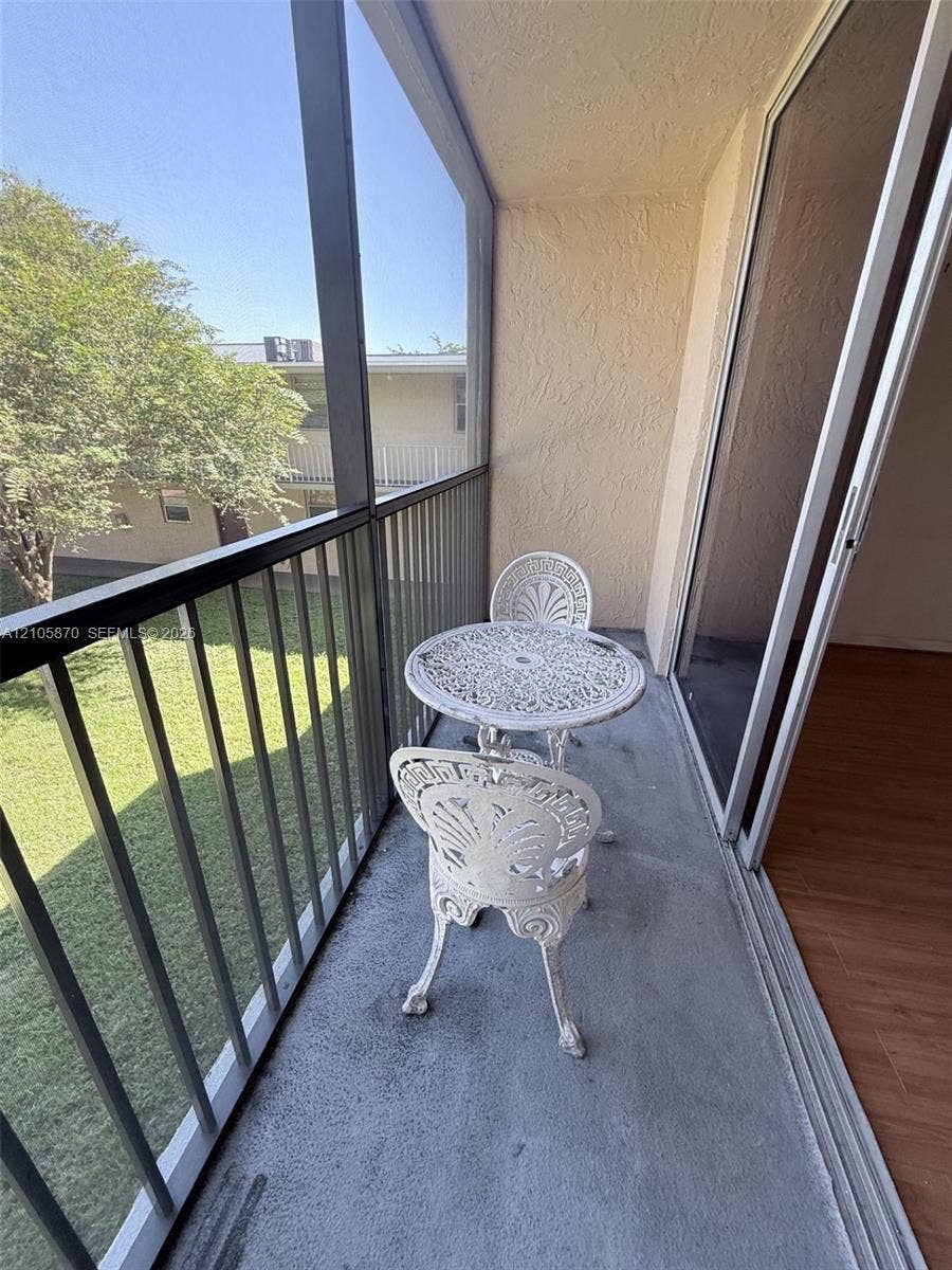 7173 Orange Drive, #204B, Davie, FL 33314 Screened-in balcony featuring concrete flooring, a metal frame enclosure, and sliding glass door access