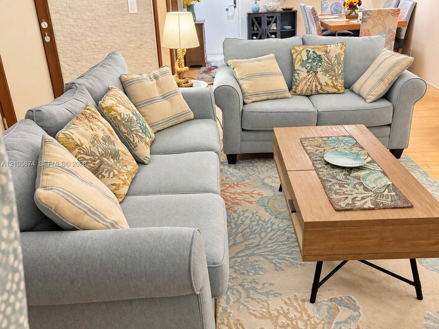Open-concept interior featuring wood-finish flooring and textured stone accent wall