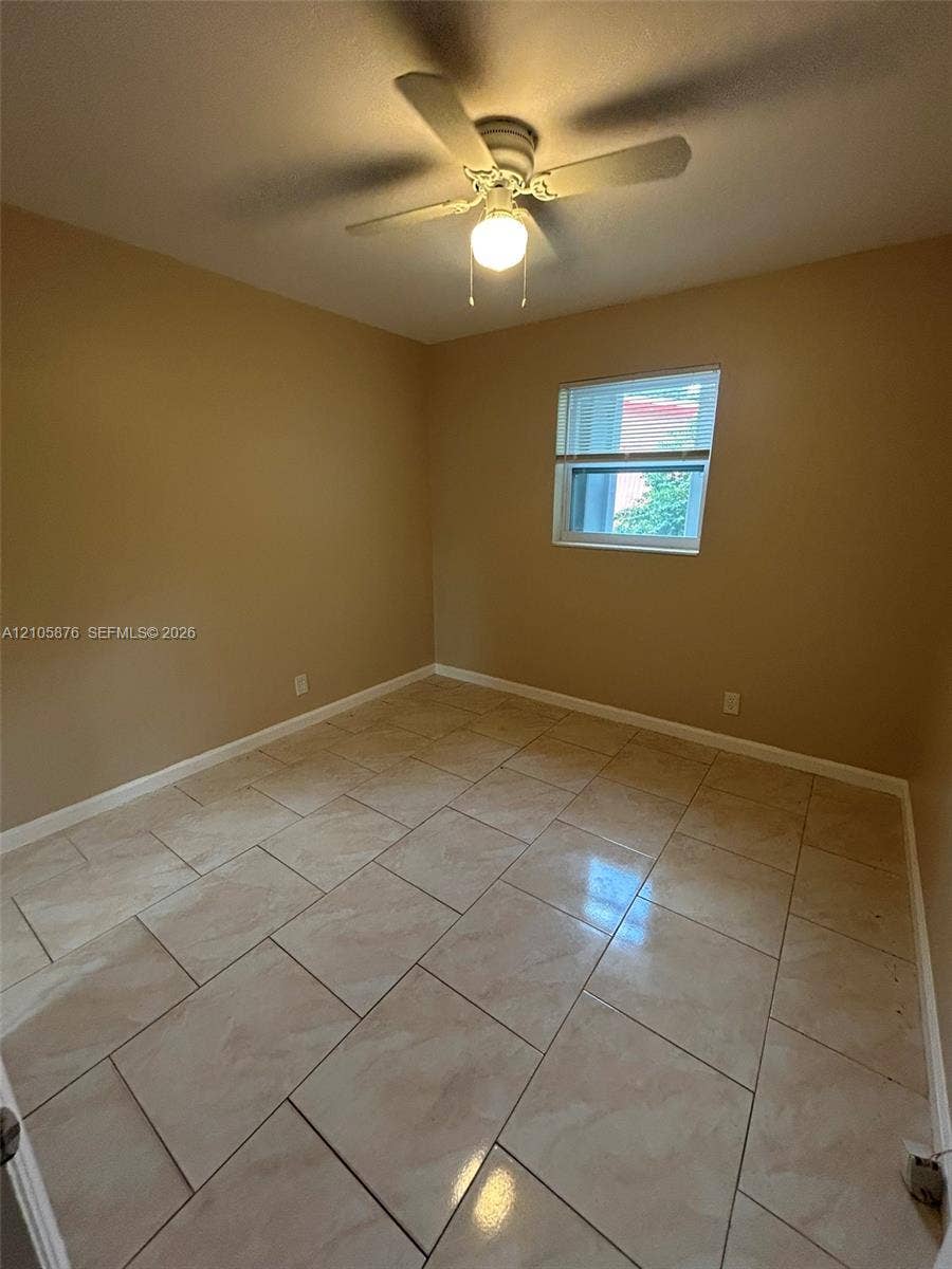 Riviera Beach, Riviera Beach, FL 33404 Neutral wall tones, large-format tile flooring, and a ceiling-mounted light fixture with integrated fan