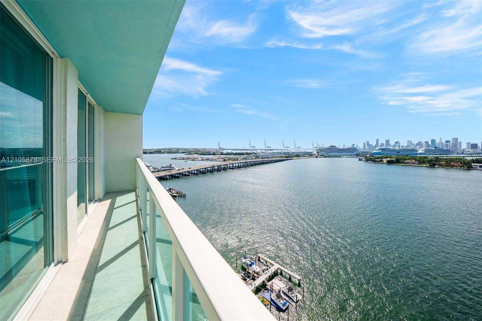 650 West Avenue, #1807, Miami Beach, FL 33139 Waterfront balcony with floor-to-ceiling glass doors, expansive bay vistas, and modern glass railings