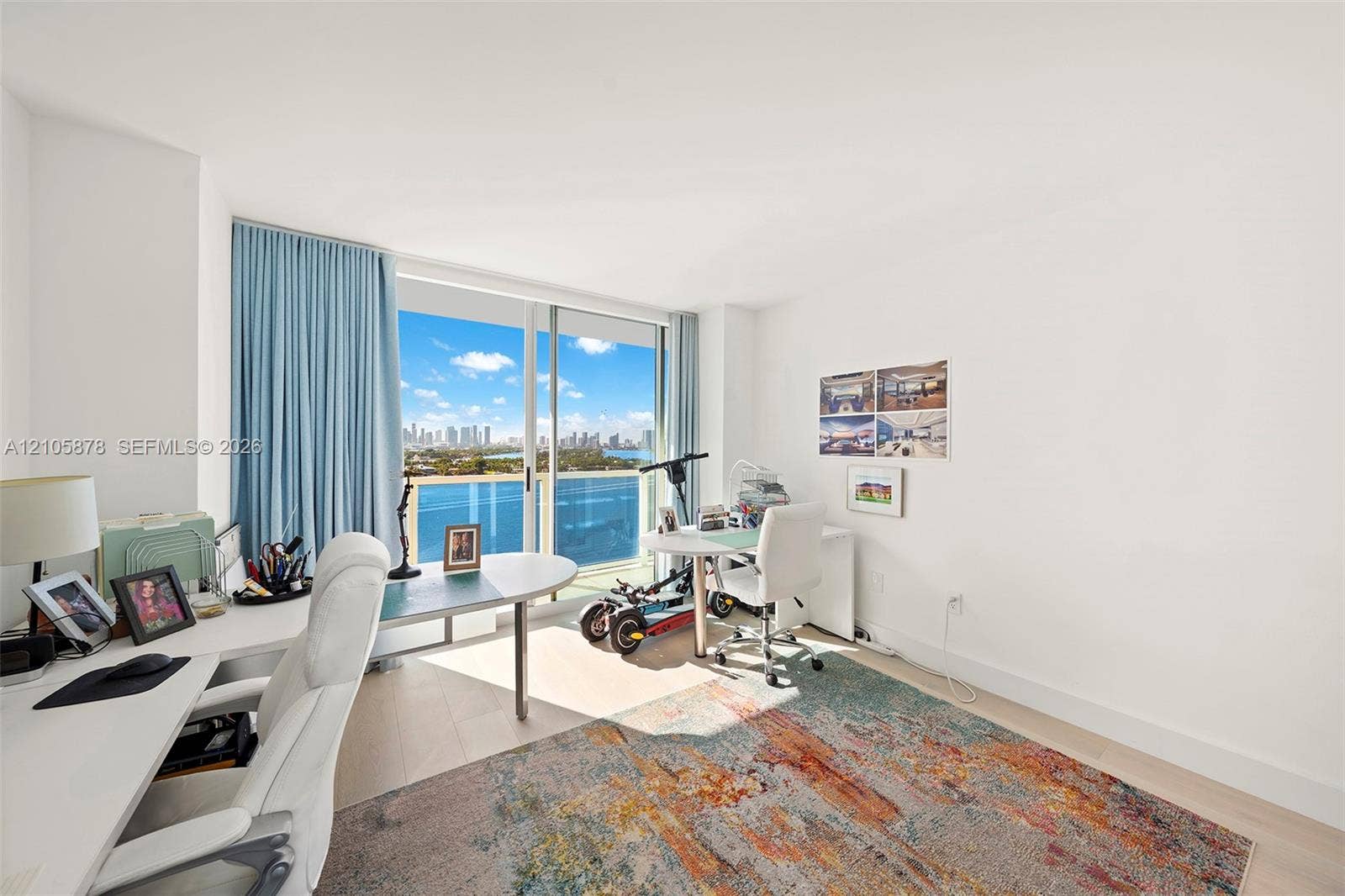 650 West Avenue, #1807, Miami Beach, FL 33139 Floor-to-ceiling sliding glass door, light-toned wood-finish flooring, and expansive water and skyline backdrop