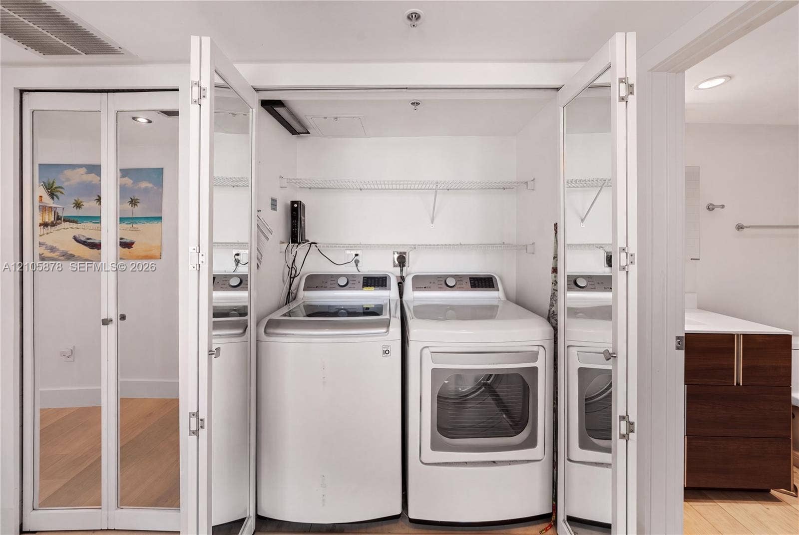 650 West Avenue, #1807, Miami Beach, FL 33139 Laundry closet featuring white bifold mirrored doors and built-in wire shelving