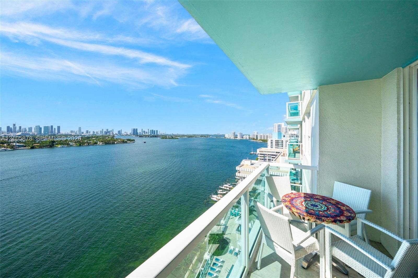 650 West Avenue, #1807, Miami Beach, FL 33139 Covered balcony featuring glass railing and expansive water and city skyline outlooks