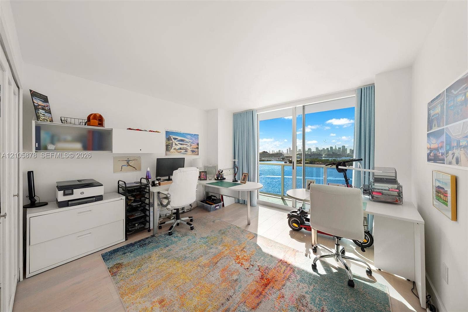 650 West Avenue, #1807, Miami Beach, FL 33139 Floor-to-ceiling sliding glass door, balcony with glass railing, wood-finish flooring, and built-in wall cabinetry