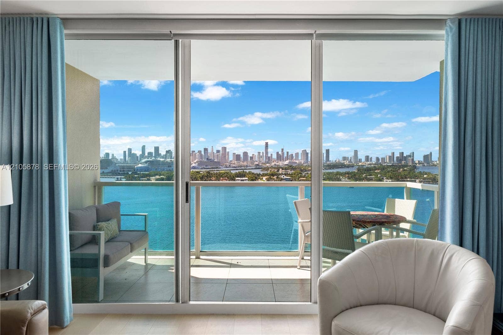 650 West Avenue, #1807, Miami Beach, FL 33139 Floor-to-ceiling sliding glass doors, private balcony, tile balcony flooring, and glass railing, featuring a coastal and urban skyline backdrop