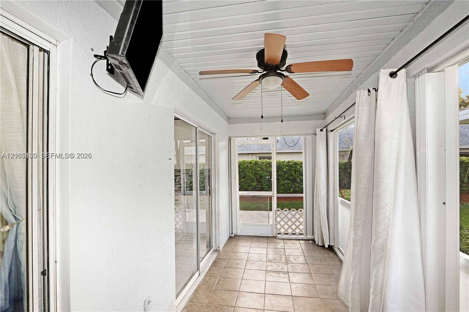 527 SE 21st Drive, Homestead, FL 33033 Enclosed patio featuring tiled flooring, a beadboard ceiling, a ceiling fan, and screened wall panels