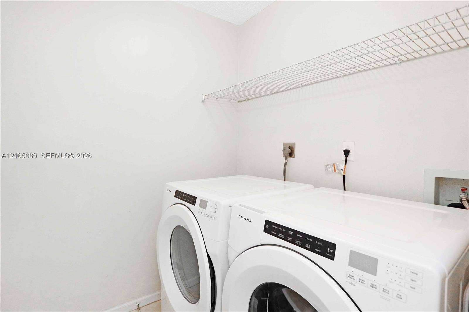527 SE 21st Drive, Homestead, FL 33033 Dedicated laundry area featuring white side-by-side appliances and overhead wire shelving