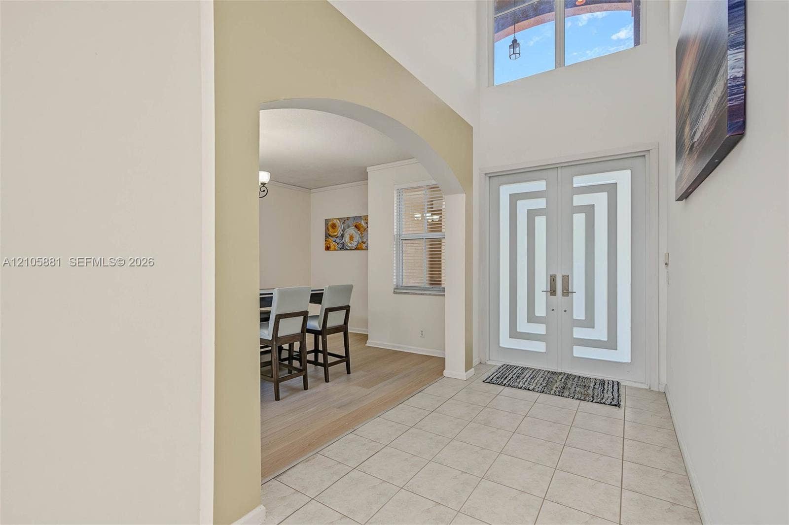 1588 SW 191st Avenue, Pembroke Pines, FL 33029 Entryway featuring double doors with geometric frosted glass inserts, tile flooring, soaring vaulted ceilings, and a clerestory window