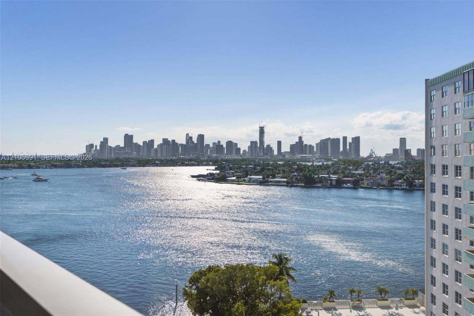 9 Island Avenue, #1215, Miami Beach, FL 33139 Elevated balcony with a metallic railing overlooking an expansive waterway and a prominent urban skyline