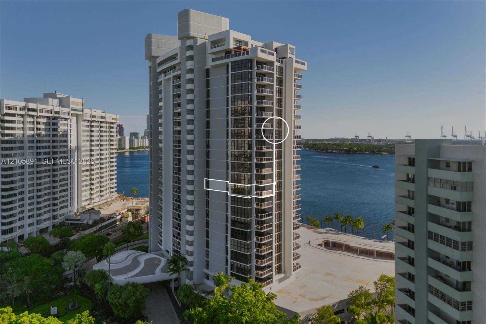 9 Island Avenue, #1215, Miami Beach, FL 33139 High-rise residential tower featuring a concrete facade, tiered architectural balconies, glass-paneled exterior walls, and a porte-cochere entrance