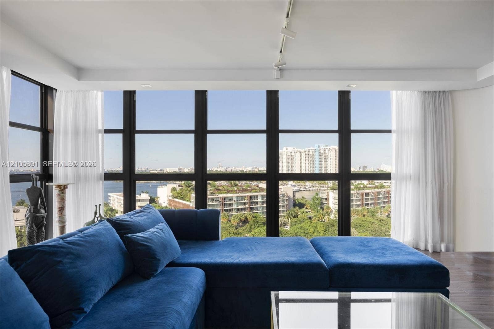 9 Island Avenue, #1215, Miami Beach, FL 33139 Floor-to-ceiling windows with dark-finish frames, wood-finish flooring, and track lighting