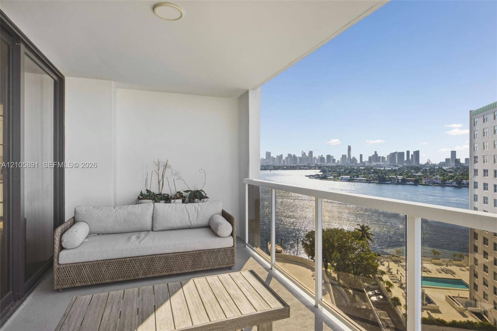 9 Island Avenue, #1215, Miami Beach, FL 33139 Covered balcony featuring white walls, concrete flooring, and a glass-panel railing with metallic framing