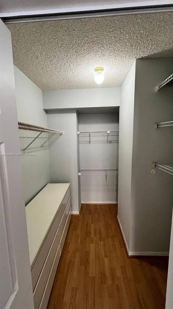600 Three Islands Boulevard, #913, Hallandale Beach, Hallandale Beach, FL 33009 Walk-in storage space featuring wood-finish flooring, white built-in cabinetry, and multi-level wire shelving