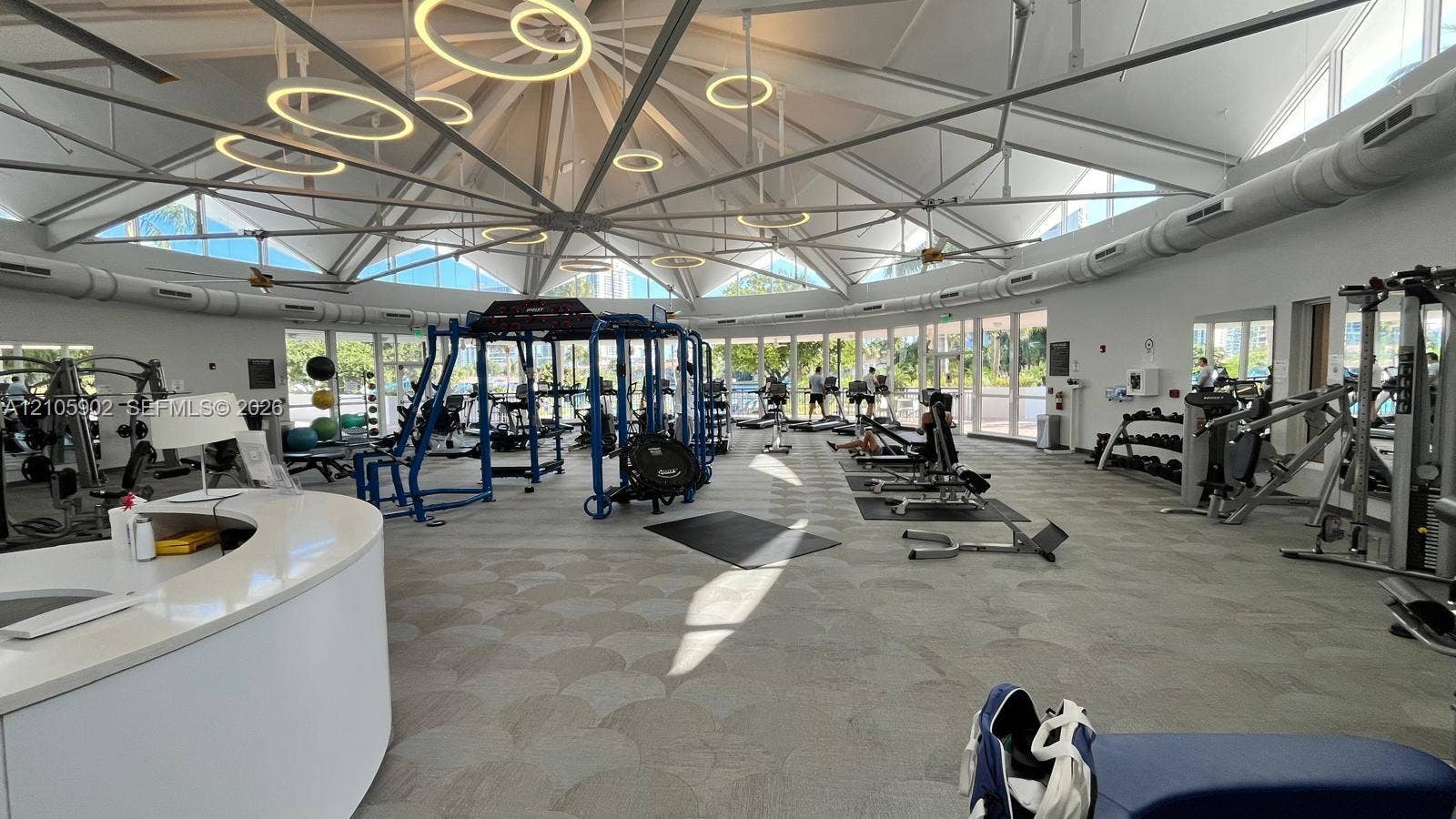 600 Three Islands Boulevard, #913, Hallandale Beach, Hallandale Beach, FL 33009 Expansive fitness center featuring a high-pitched vaulted ceiling, exposed structural steel trusses, circular pendant lighting, and a wrap-around wall of glass windows