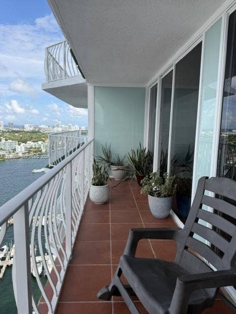 7601 E Treasure Drive, #2417, North Bay Village, North Bay Village, FL 33141 Covered balcony featuring tile flooring, white metal railings, and floor-to-ceiling glass sliding doors