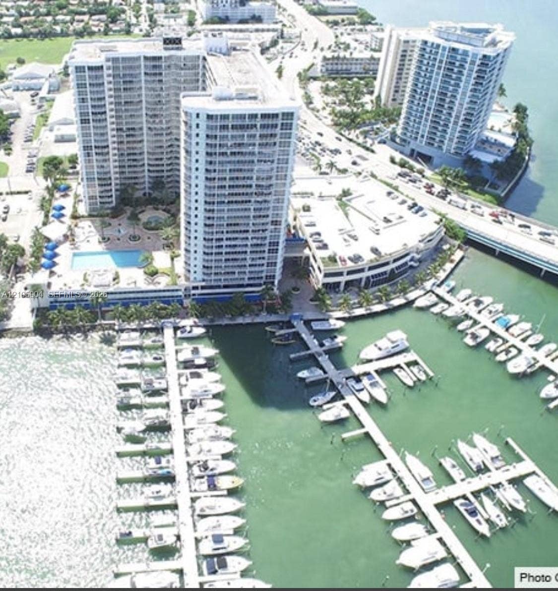 7601 E Treasure Drive, #2417, North Bay Village, North Bay Village, FL 33141 High-rise waterfront property featuring a private marina, swimming pool, landscaped grounds, and attached parking structure
