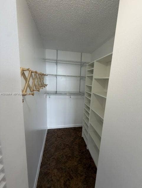 7601 E Treasure Drive, #2417, North Bay Village, North Bay Village, FL 33141 Storage space featuring white built-in shelving units, adjustable wire shelving, and a wall-mounted wooden accordion-style rack