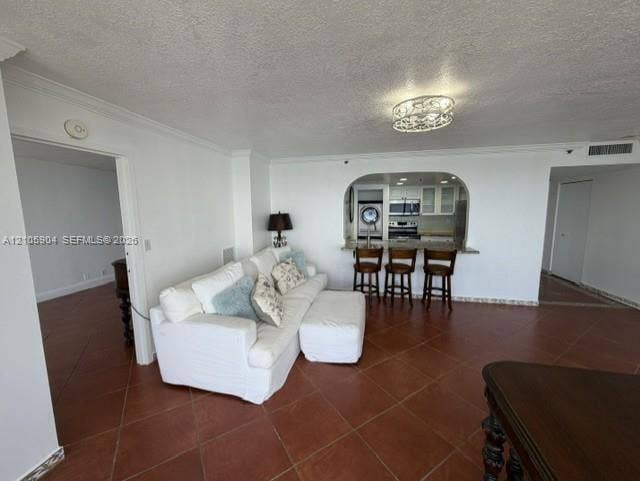 7601 E Treasure Drive, #2417, North Bay Village, North Bay Village, FL 33141 Interior featuring terracotta-style tile flooring, arched wall opening, breakfast bar, and decorative ceiling-mounted light fixture