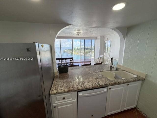 7601 E Treasure Drive, #2417, North Bay Village, North Bay Village, FL 33141 Kitchen featuring stone countertops, white cabinetry, stainless steel refrigerator, white dishwasher, and double-basin undermount sink with arched opening