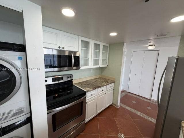7601 E Treasure Drive, #2417, North Bay Village, North Bay Village, FL 33141 Kitchen featuring white cabinetry with glass-panel upper doors, stone-surface countertops, stainless steel appliances, and tiled flooring