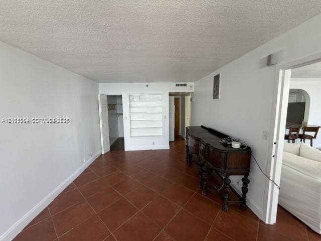 7601 E Treasure Drive, #2417, North Bay Village, North Bay Village, FL 33141 Interior space featuring large-format ceramic tile flooring, built-in shelving, and a walk-in closet with integrated storage rack