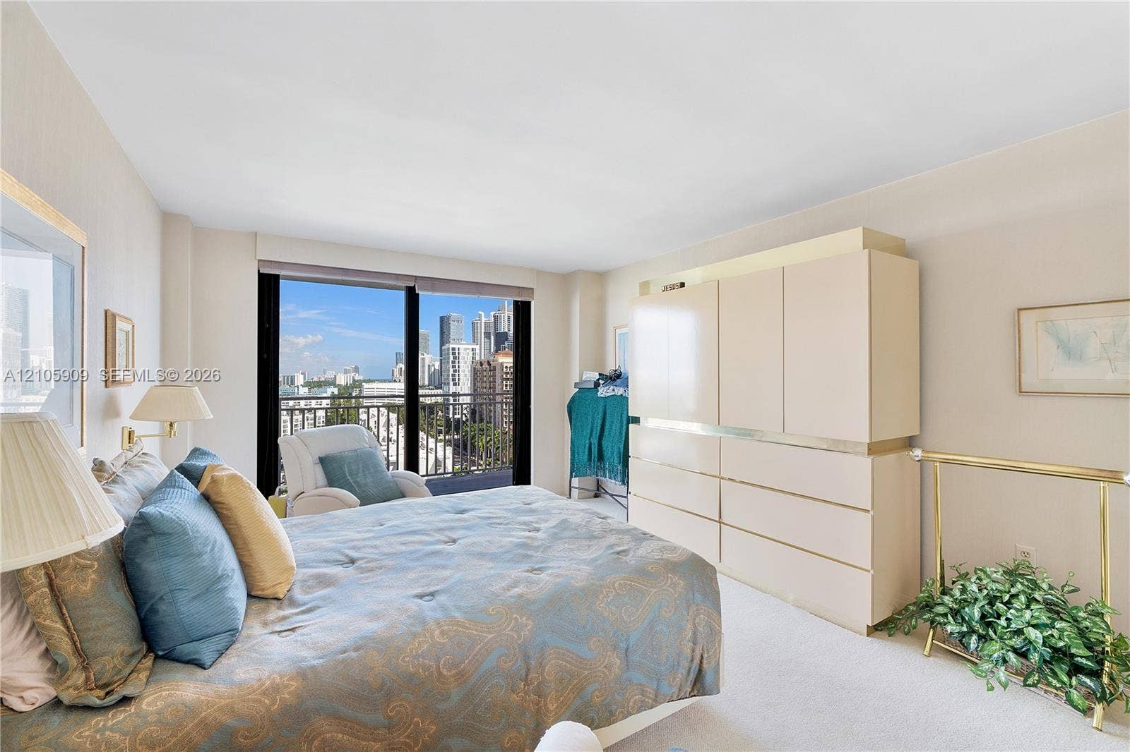 Floor-to-ceiling sliding glass doors with balcony access, expansive urban skyline backdrop, and built-in floor-to-ceiling cabinetry