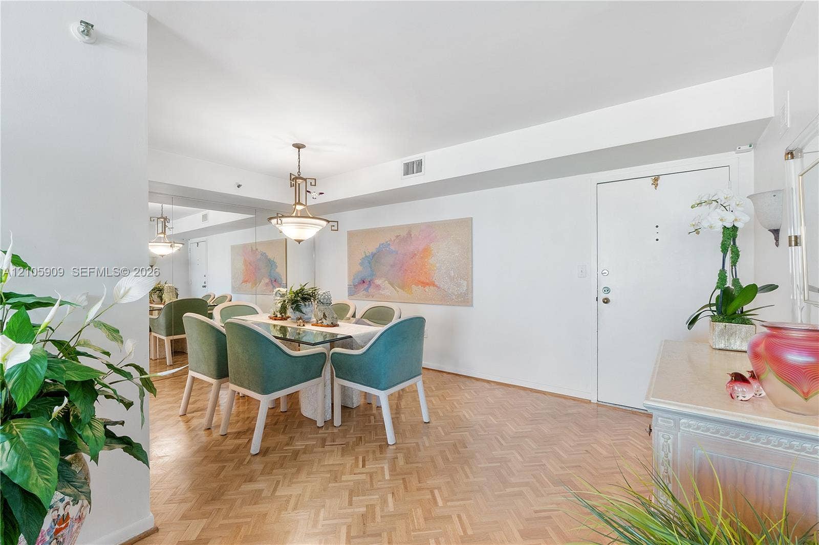 Parquet wood-finish flooring, full-wall mirror, and multi-tiered decorative pendant lighting fixture