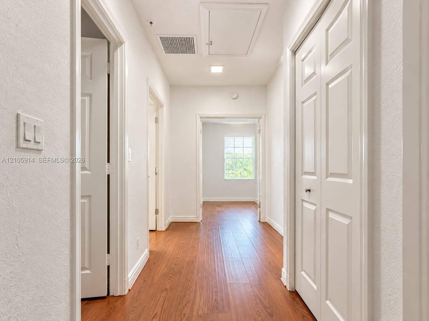 11102 NW 83rd Street, #216, Doral, FL 33178 Hallway featuring wood-finish flooring, white panel doors, and recessed lighting