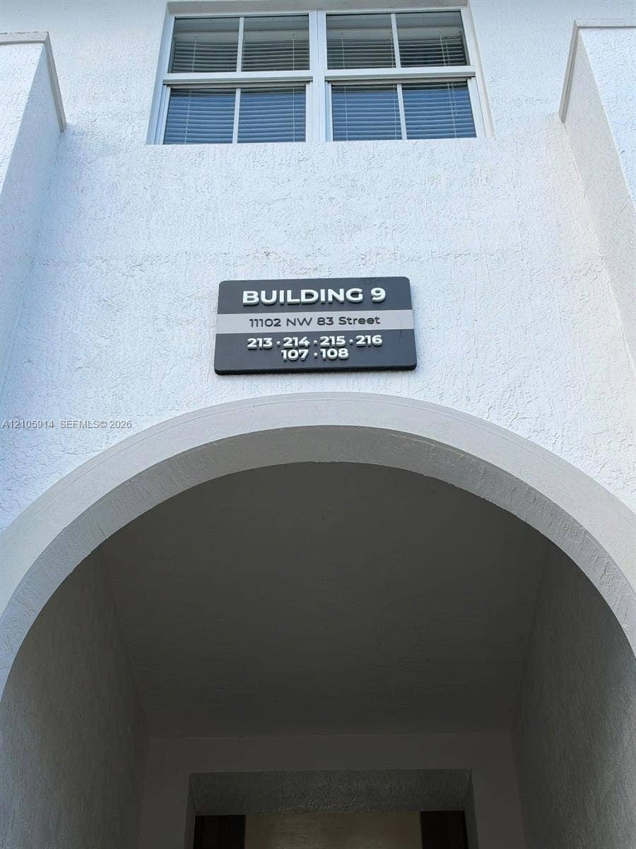 11102 NW 83rd Street, #216, Doral, FL 33178 Stucco exterior featuring a prominent architectural archway and multi-pane window