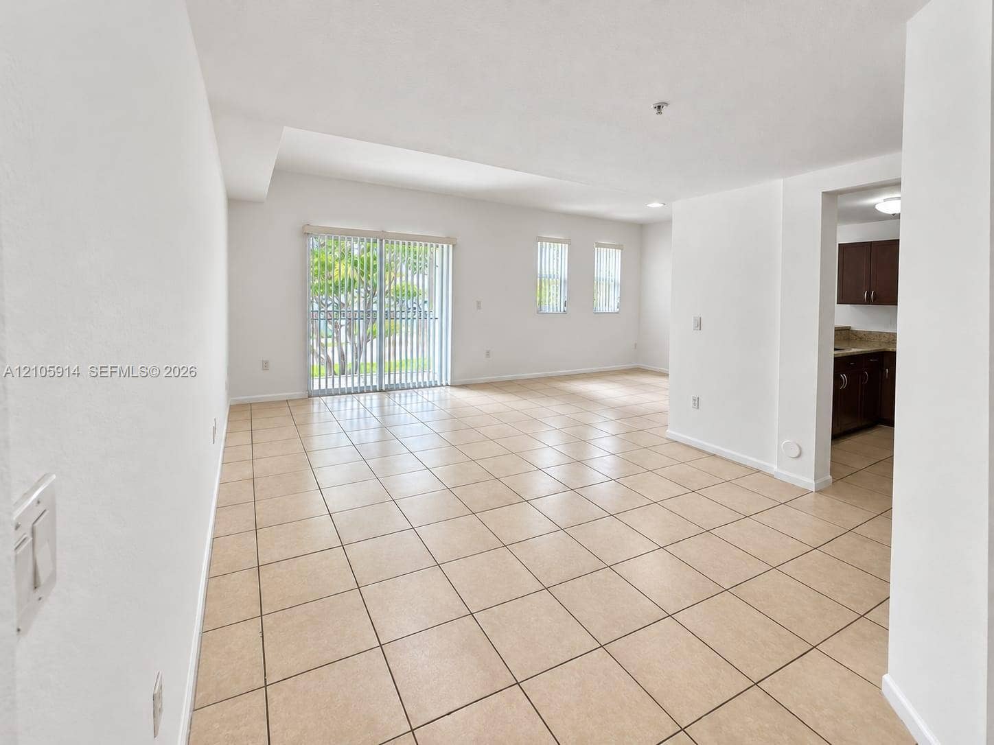11102 NW 83rd Street, #216, Doral, FL 33178 Open-concept interior featuring neutral tile flooring, sliding glass patio doors, and recessed lighting