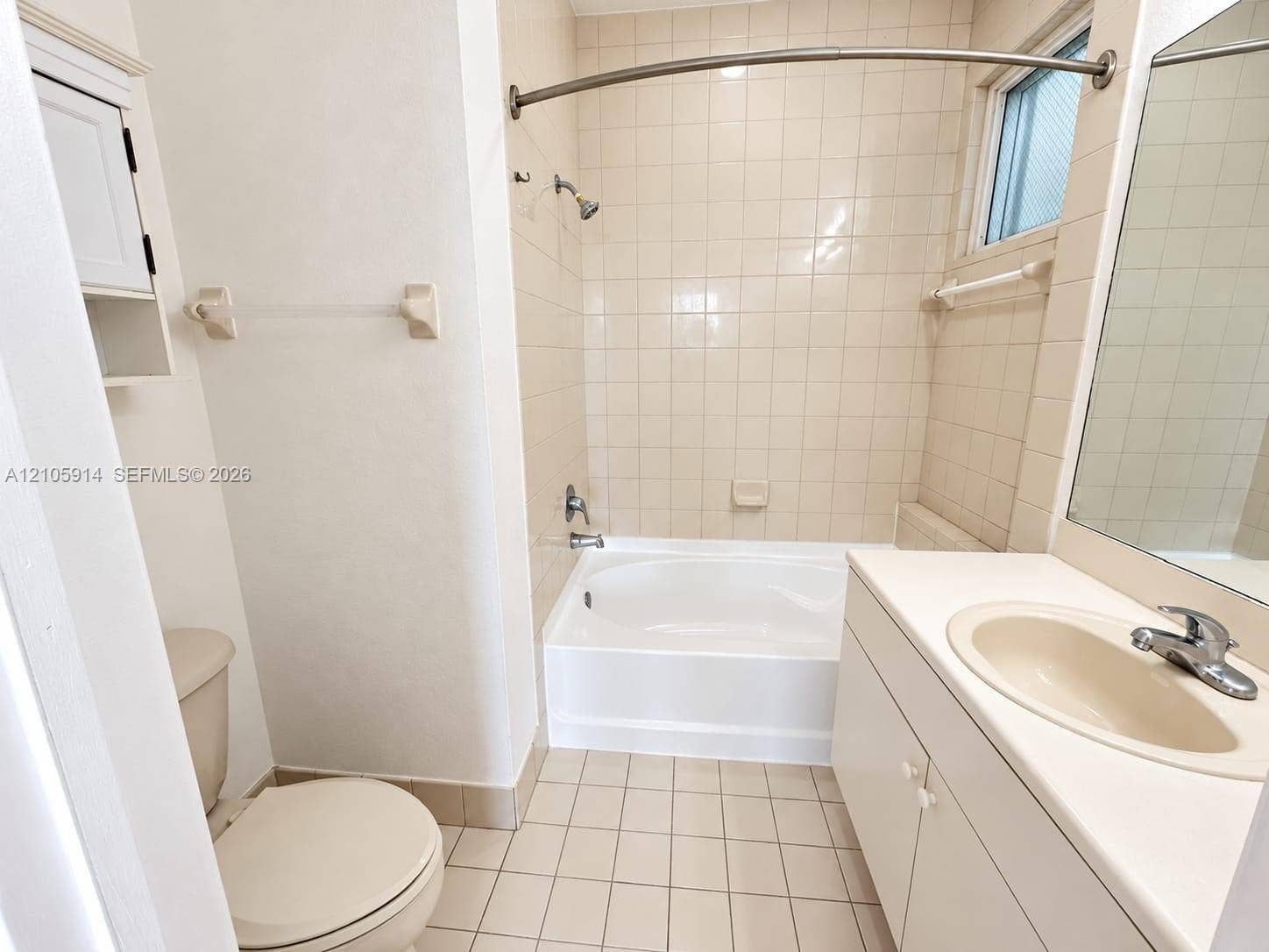 11102 NW 83rd Street, #216, Doral, FL 33178 Bathroom featuring a white vanity cabinet with an integrated sink, tiled tub and shower surround, curved shower rod, and ceramic tile flooring