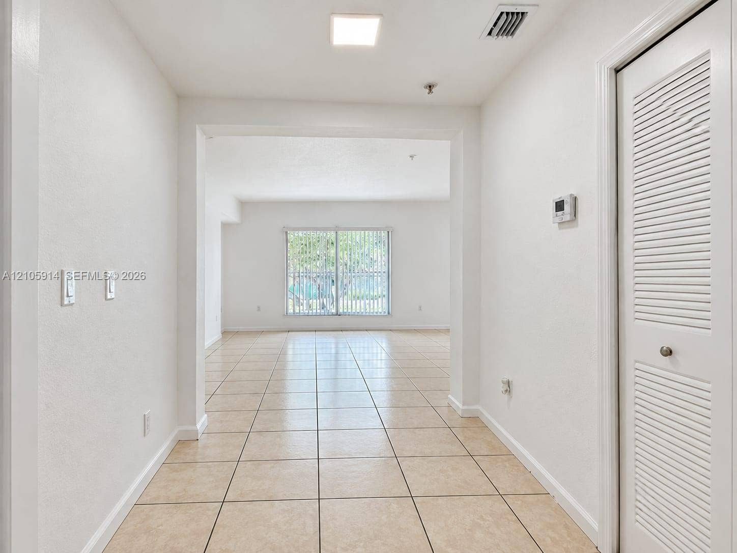11102 NW 83rd Street, #216, Doral, FL 33178 Interior space featuring large-format ceramic tile flooring, neutral wall finishes, recessed ceiling lighting, and a closet with bifold louvered doors