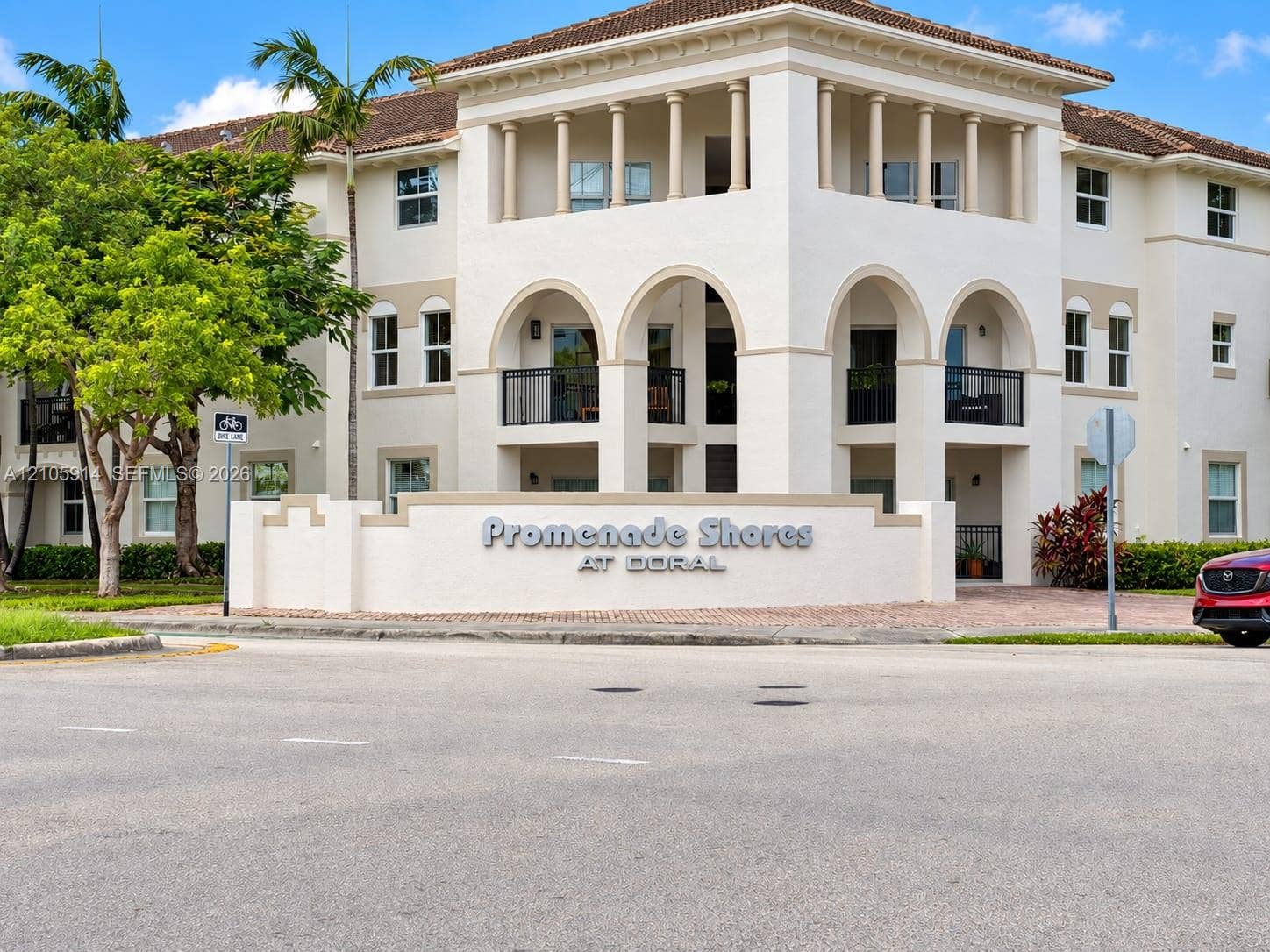 11102 NW 83rd Street, #216, Doral, FL 33178 Mediterranean-inspired exterior architecture featuring arched entryways, multi-level balconies with black metal railings, and decorative columns