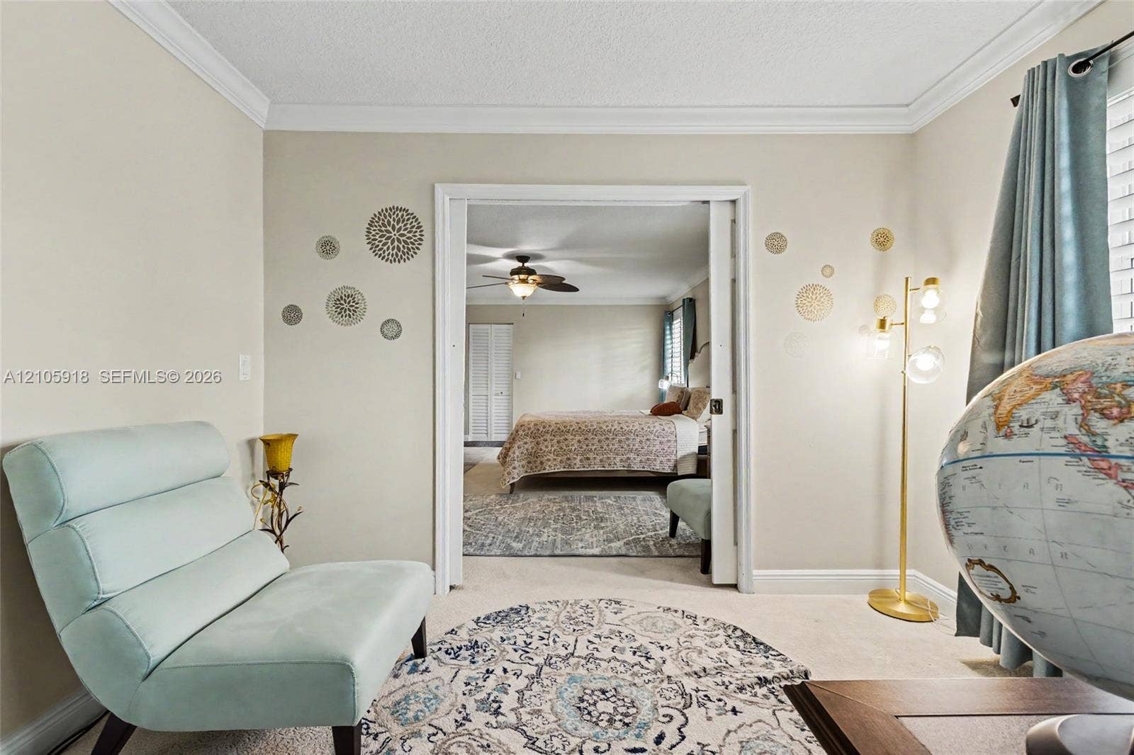 Room featuring crown molding, neutral wall finishes, and a sliding door entry