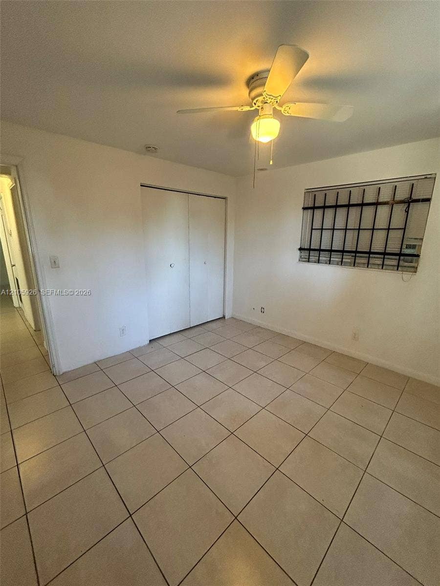 1601 W Avenue H W, Riviera Beach, Riviera Beach, FL 33404 Room featuring tile flooring, ceiling fan with integrated lighting, and closet with double doors