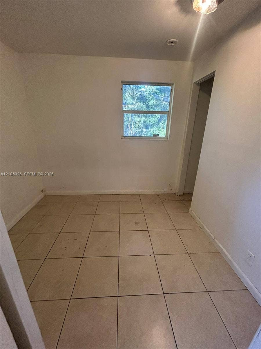 1601 W Avenue H W, Riviera Beach, Riviera Beach, FL 33404 Interior space featuring neutral wall-to-wall ceramic tile flooring and a single-pane window